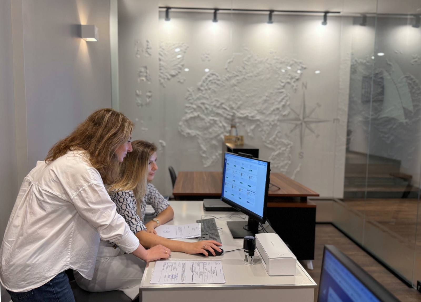 Two Nautica coordinators reviewing seafarer documents on screen